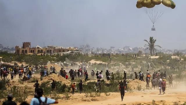 Палестинцы в Газе спешат за гуманитарной помощью, сброшенной на парашютах