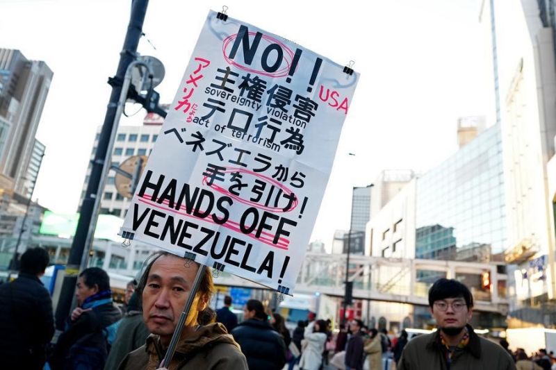 4 января, Токио. Мужчина держит плакат в поддержку Венесуэлы во время демонстрации в столице Японии. /Фото: Синьхуа/